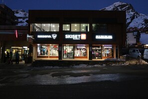A building with multiple storefronts including Rossignol, Skiset, and a pharmacy. - 200m from resort center, 5th floor, balcony, tv, 26m², Val Thorens (Val Thorens)
