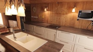 A kitchen with a white sink, wooden cabinets, and a built-in oven.