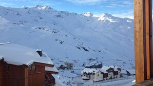 A snowy mountain landscape with a wooden building and a ski resort in the foreground. - 3rd floor, balcony, tv, ski locker, 56m², Val Thorens (Val Thorens)