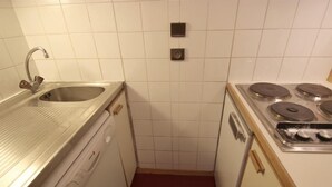 A compact kitchen with a stainless steel sink, a built-in oven, and a stovetop. - 50m from ski slopes, 2nd floor, balcony, tv, 35m², Val Thorens (Val Thorens)