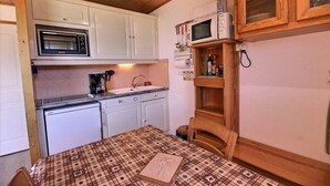 A compact kitchen with white cabinets, a built-in microwave, a coffee maker, and a small sink. - 200m from resort center, 2nd floor, view mountain, balcony, tv, 35m², Peisey-Vallandry (Landry)