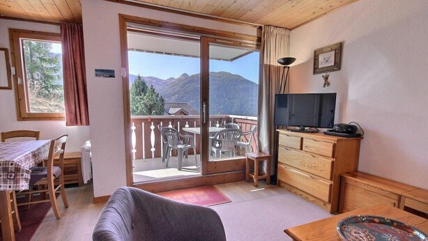 A cozy room with a dining table, chairs, a sofa, a TV, and a balcony with a mountain view. - 200m from resort center, 2nd floor, view mountain, balcony, tv, 35m², Peisey-Vallandry (Landry)