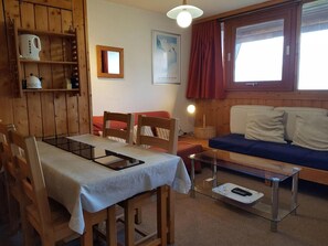 Relax in this inviting room with a dining table for two, a comfortable sofa, and a window with a view.