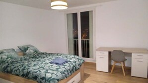 Ein Schlafzimmer mit Bett, Schreibtisch und Stuhl.