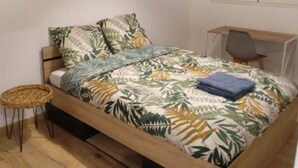 Ein Schlafzimmer mit einem Bett, einem Schreibtisch und einem Stuhl.