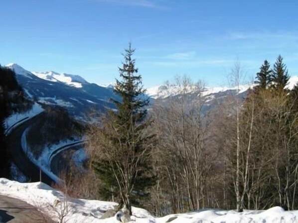 A mountainous landscape with snow-covered peaks and a clear sky.