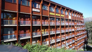 A multi-story building with balconies, a restaurant grill, and a bar-pizzeria. - 50m from ski slopes, 4th floor, view forest, balcony, tv, 25m², Les Arcs (Les Arcs)