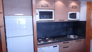 A compact kitchen with a refrigerator, microwave, stove, sink, and dishwasher. - Ski-in/ski-out & foot of the slopes, 2nd floor, view ski slopes, balcony, tv, 50m², Les Arcs (Les Arcs)