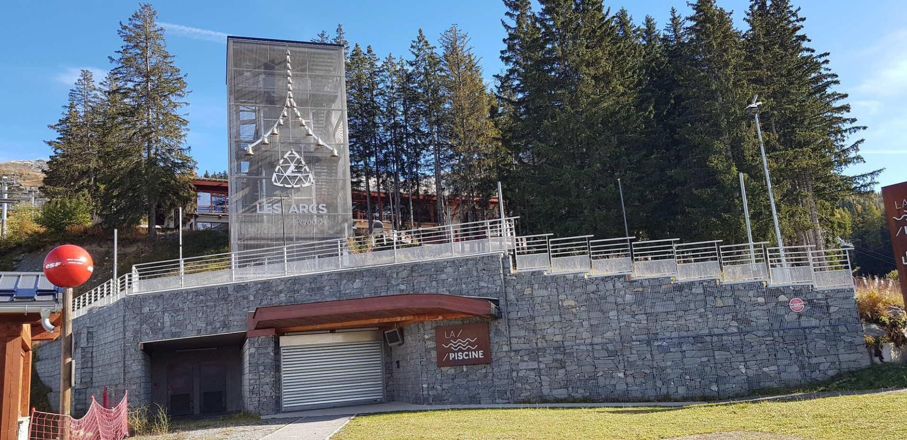 A stone building with a metal railing and a red ball on a pole.