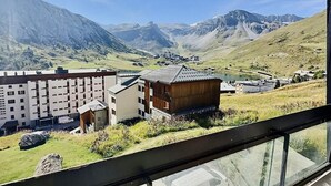 A view of a mountainous landscape with a building complex and a traditional wooden structure.