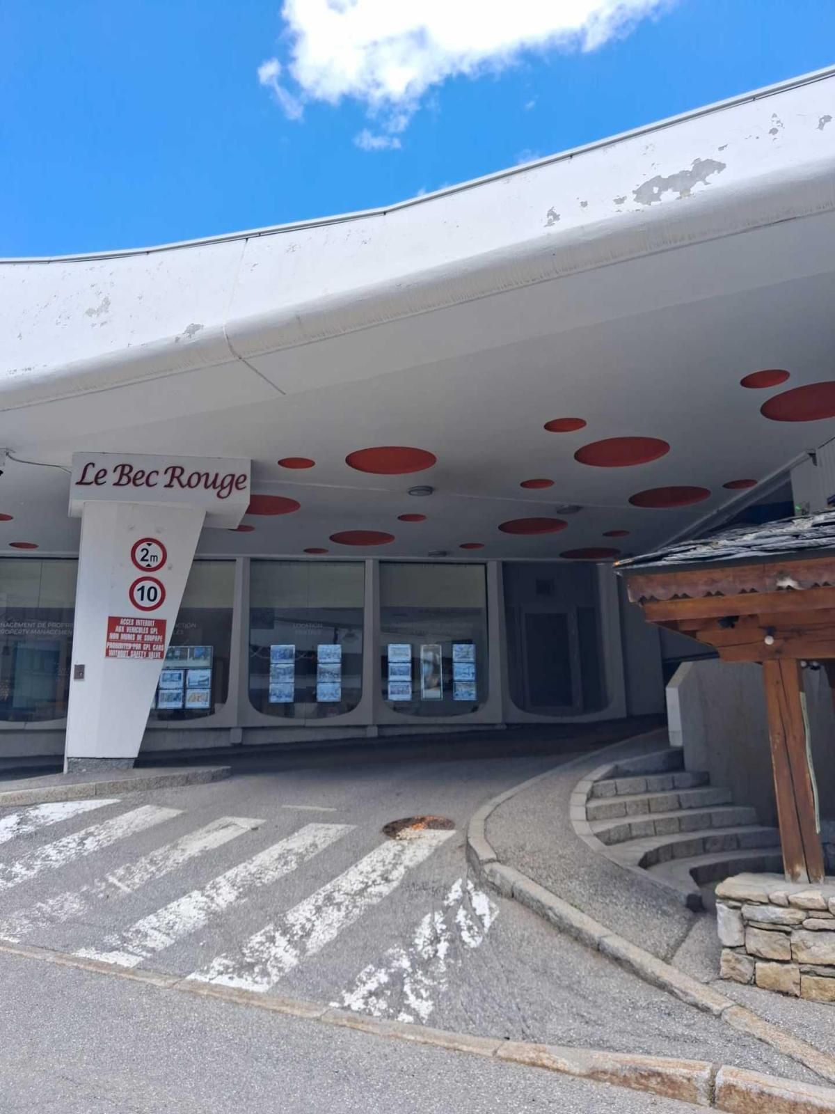 Un edificio con una facciata bianca caratteristica e motivi circolari rossi sul soffitto.