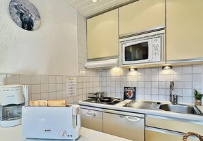 A kitchen with a stove, microwave, and a coffee maker.