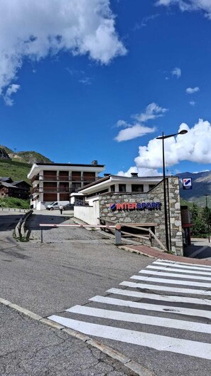 A building with a sign reading 'INTERSPORT' and a pedestrian crossing in front.