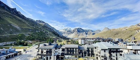 A modern town with contemporary buildings, a main road, and a mountainous backdrop.