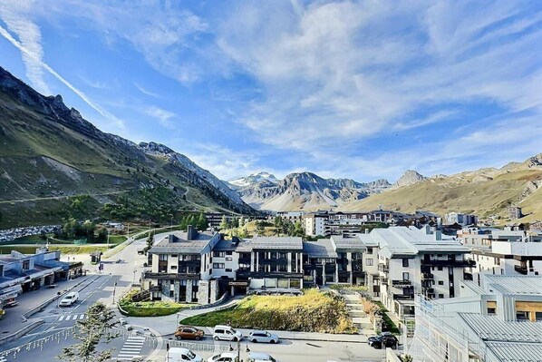 A modern town with contemporary buildings, a main road, and a mountainous backdrop.