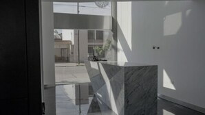 A modern interior with a marble reception desk, large windows, and a minimalist design. - LaGioconda aparthotel (Villa Maria)