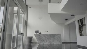 A modern interior with a marble reception desk, a glass door entrance, and a clean, minimalist design. - LaGioconda aparthotel (Villa Maria)