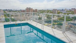 A rooftop swimming pool with a glass railing, surrounded by a cityscape view. - LaGioconda aparthotel (Villa Maria)