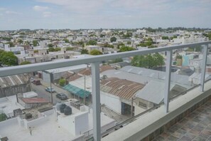 A residential area with multiple buildings, a clear sky, and a view of a street with parked cars.