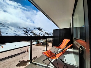 A balcony with a view of a snowy mountain and a clear sky.
