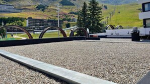 A rooftop terrace with a gravel floor, a metal fence, and a view of a mountainous landscape. - 10m from ski slopes, 1st floor, view resort, tv, ski locker, 24m², Les Menuires (Les Menuires)