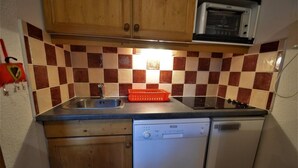 Una cucina compatta con lavastoviglie, forno a microonde e lavello.