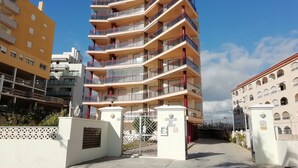 A multi-story residential building with balconies, a gated entrance, and a clear sky. - Apartamento Da Vinci 5 Inmomart (Peñiscola)