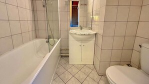 Une salle de bain avec une baignoire, un lavabo et des toilettes.