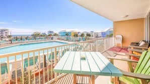 Un balcone con piscina, sedie a sdraio e un tavolo.