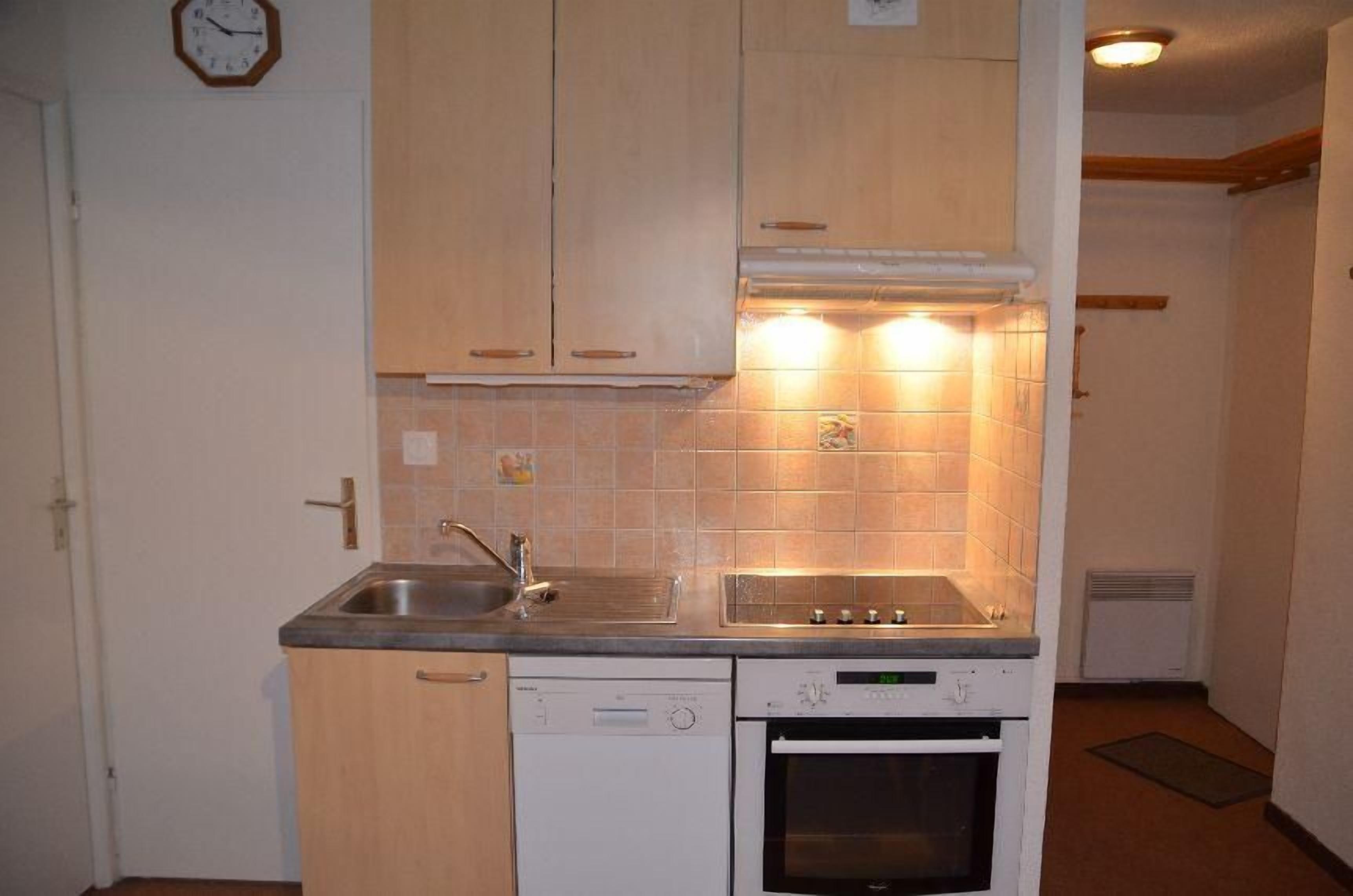 A compact kitchen with a sink, stove, and dishwasher.