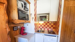 Una cocina compacta equipada con microondas, cafetera y lavavajillas.