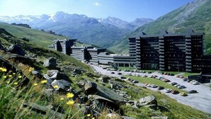Un hotel moderno con un diseño arquitectónico único, frente a un paisaje montañoso.