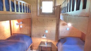 A small, cozy room with two beds, a small table with a lamp, and a window. - 2nd floor, terrace, tv, ski locker, 71m², Méribel (Méribel - Les Allues)