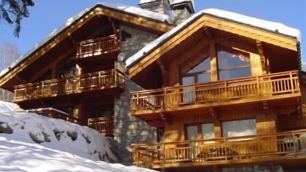 A wooden chalet with balconies, set against a snowy backdrop. - 2nd floor, terrace, tv, ski locker, 71m², Méribel (Méribel - Les Allues)