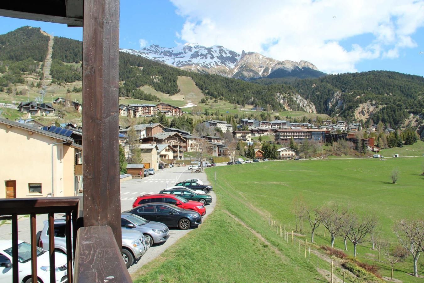 A mountain town with a parking lot, buildings, and a view of snow-capped mountains.