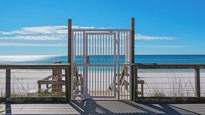 A wooden deck with a metal gate leading to a beach. - GULF VIEWS~Private beach! Comp beach chairs! (Miramar Beach)