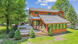 A two-story wooden cabin with a deck, a hot tub, and a covered patio area. - A spectacular space for every season-in winter a real skier's destination! (Canaan Valley)
