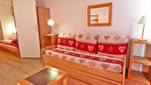 Een gezellige kamer met een houten bank, een klein houten tafeltje en een spiegel aan de muur.