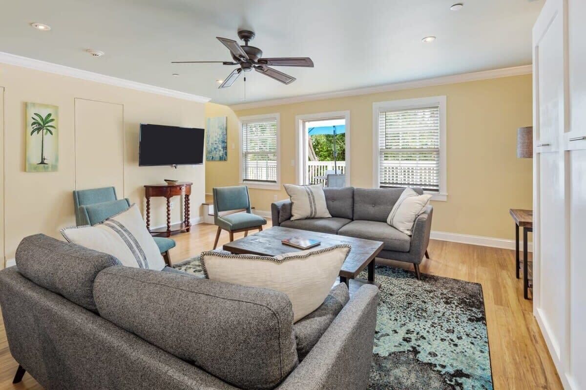 A living room with a grey sofa, a coffee table, and a television.
