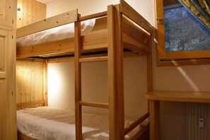 A bunk bed room with a window, wooden walls, and a small table. - 150m from ski slopes, 4th floor, balcony, fireplace or stove, ski locker, 39m², Méribel (Méribel - Les Allues)