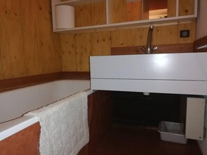 Bathroom features a white sink, modern faucet, and a bathtub with a towel.