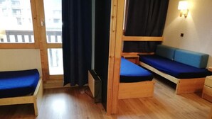 Une pièce avec deux lits superposés, un canapé et une petite table.