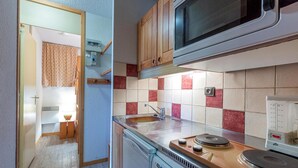 A compact kitchen with a microwave, a sink, and a coffee maker. - 200m from ski slopes, floor -1, view ski slopes, terrace, tv, ski locker, 21m², Valmorel (Valmorel)
