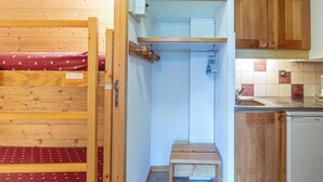 A compact kitchen with wooden cabinets, a small countertop, and a sink. - 200m from ski slopes, floor -1, view ski slopes, terrace, tv, ski locker, 21m², Valmorel (Valmorel)