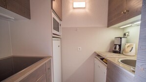 Una cocina compacta equipada con microondas, cafetera y lavavajillas.