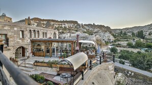 Ein Restaurant mit Außenbereich und Blick auf eine gebirgige Landschaft.