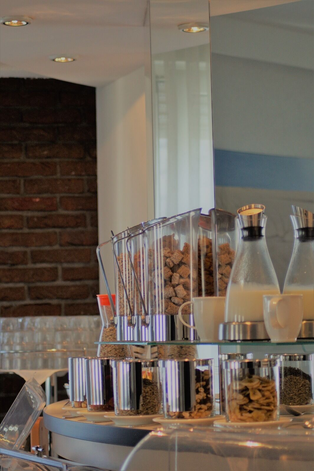 A breakfast bar with various food containers and a coffee machine.