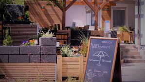 A wooden pergola with a chalkboard sign welcoming visitors. - Hotel-Restaurant Zum Schwanen (Wermelskirchen)