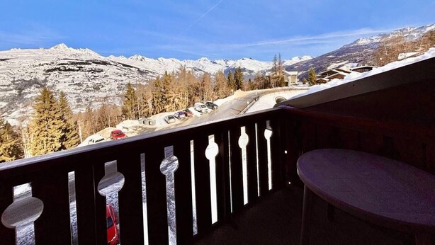 Un balcone con vista su montagne innevate e una strada.