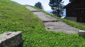 A stone pathway leading to a wooden building with a view of a mountain. - 300m from resort center, view mountain, terrace, tv, ski locker, 20m², Montchavin La Plagne (Bellentre)